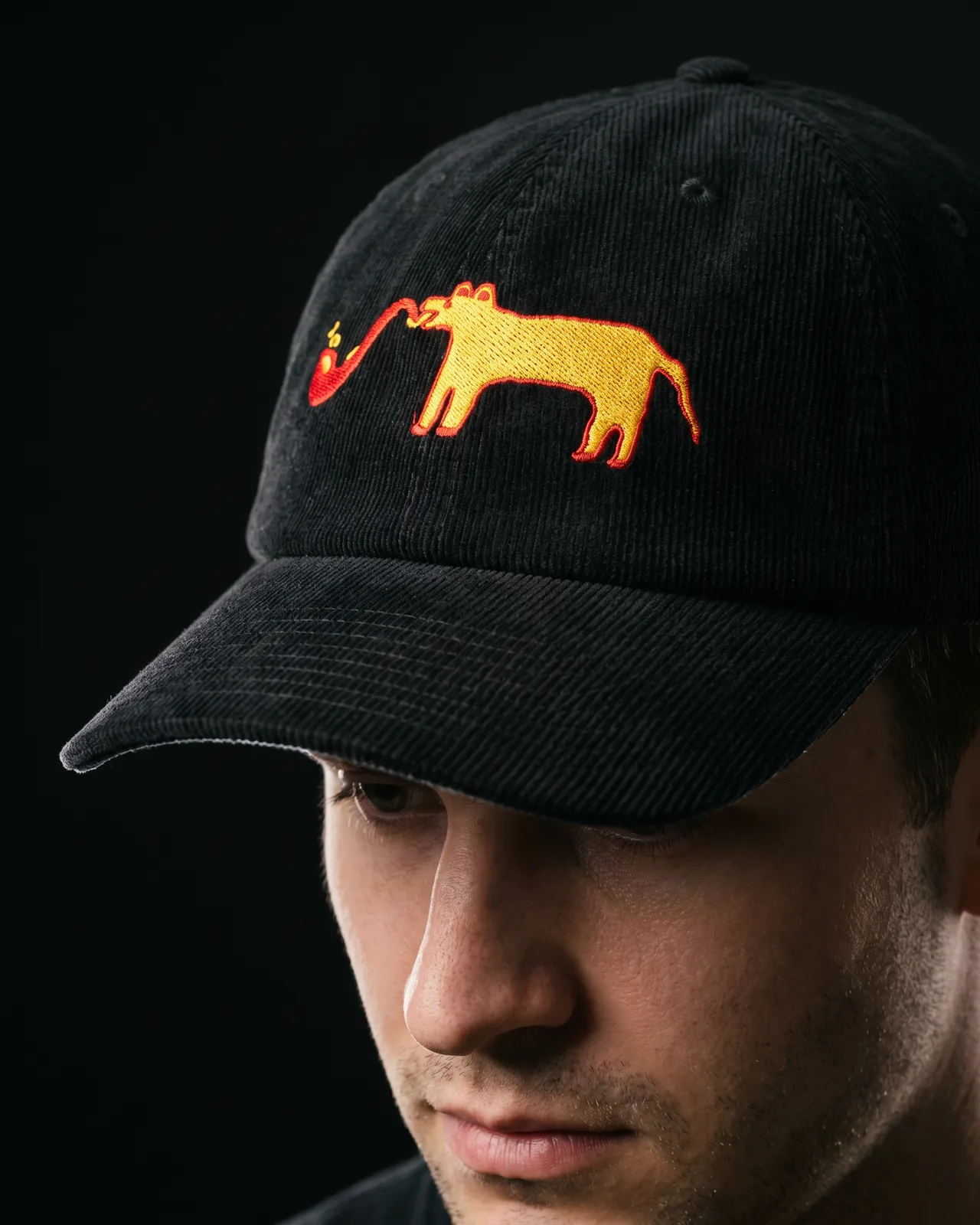 Man wearing the black corduroy dad cap (corduroy hat), studio portrait cropped at the lip